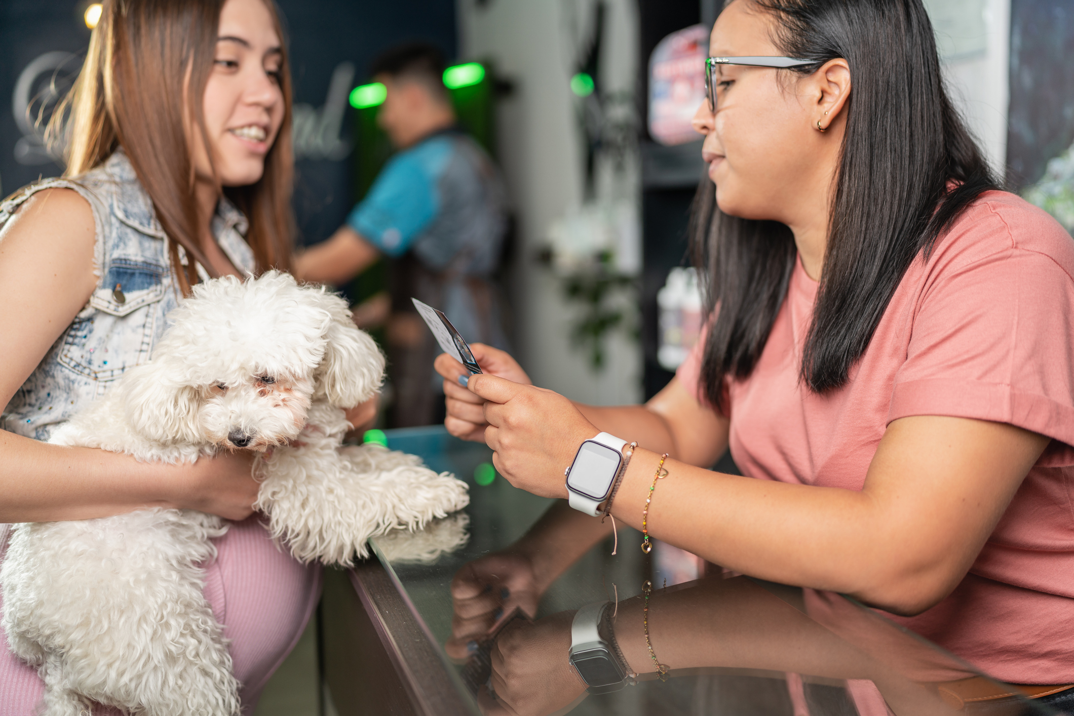 Close up photo of a Latina woman attending a costumer with a dog for SEO-for-pet-resorts blog.