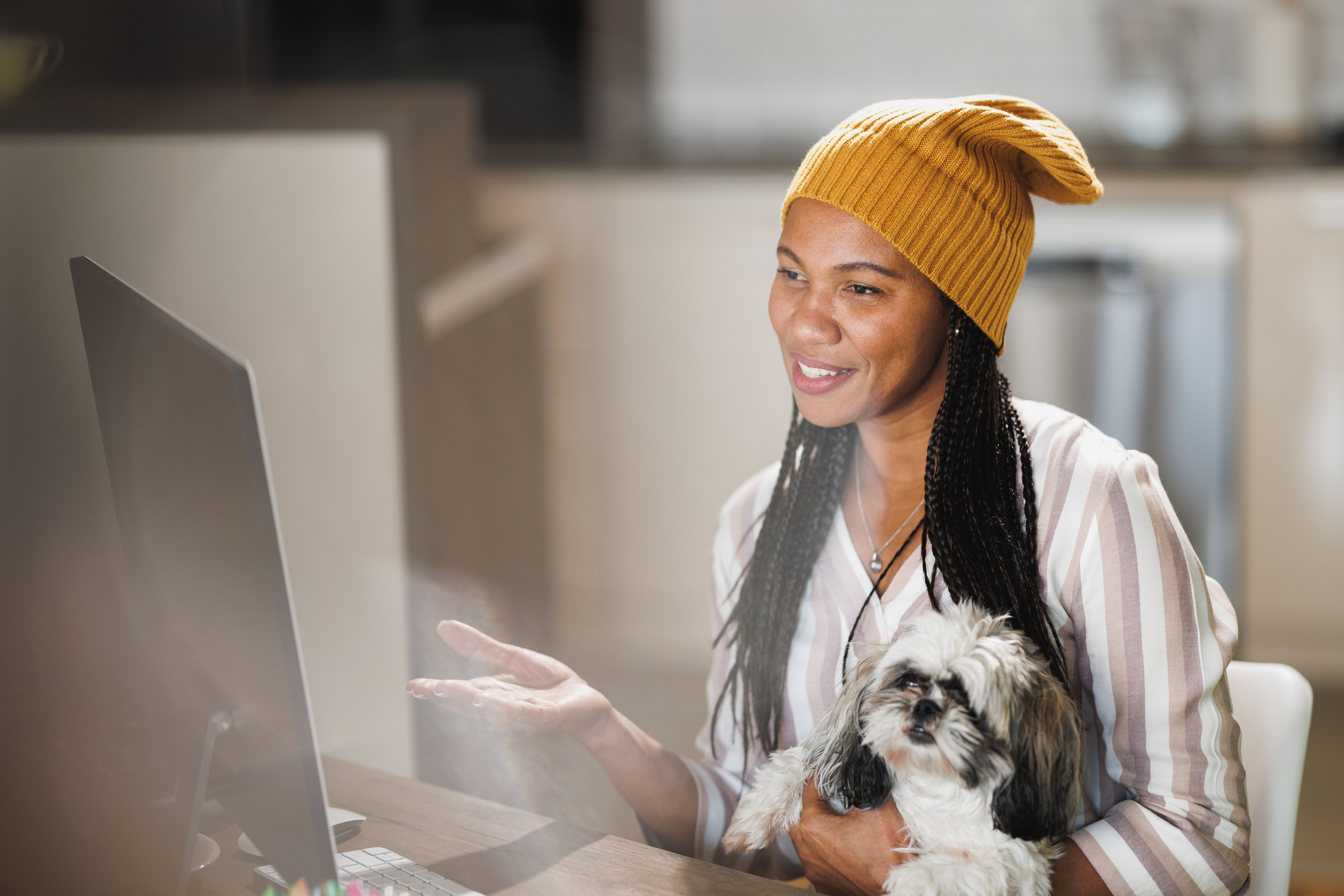 A woman and her dog at computer for multi-location-facebook-pages blog.